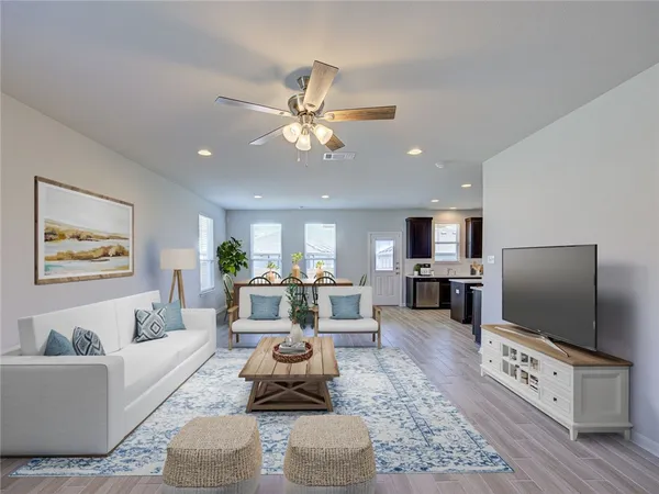 a living room with furniture a flat screen tv and a dining table with wooden floor
