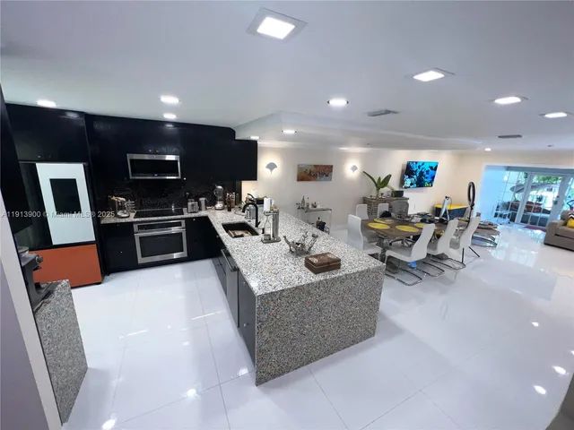 a living room with furniture kitchen and a wooden floor