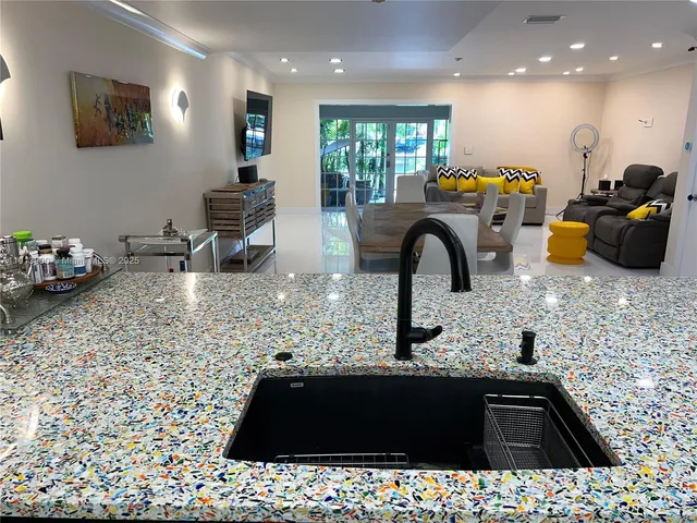 a kitchen with sink and mirror