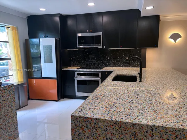 a kitchen with kitchen island granite countertop stainless steel appliances and sink