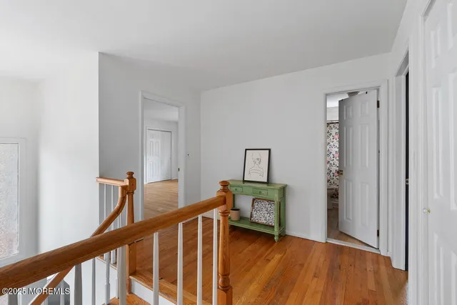 a view of a hallway with wooden floor and stairs
