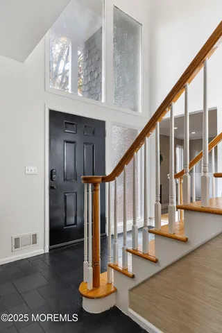 a view of entryway and hall with wooden floor