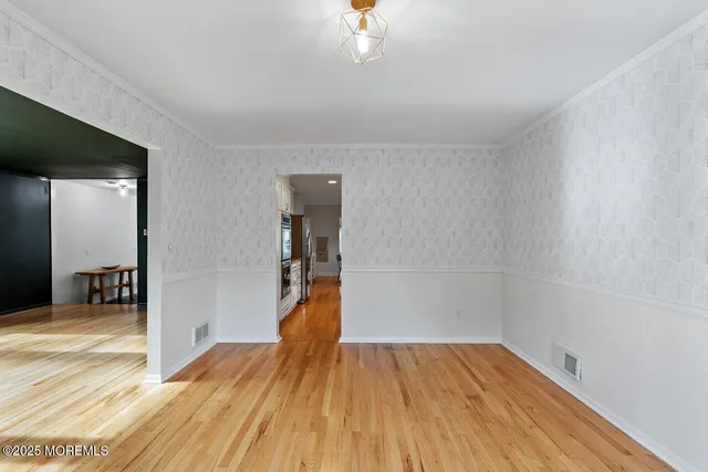 a view of a room with wooden floor and a ceiling fan