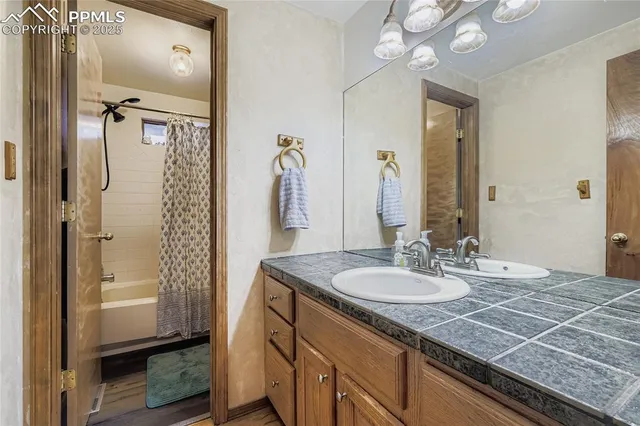 a bathroom with a granite countertop sink a mirror and shower