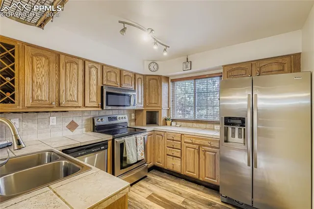 a kitchen that has a sink cabinets counter space and stainless steel appliances