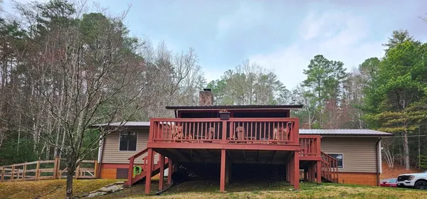 a view of a house with pool and trees in the background