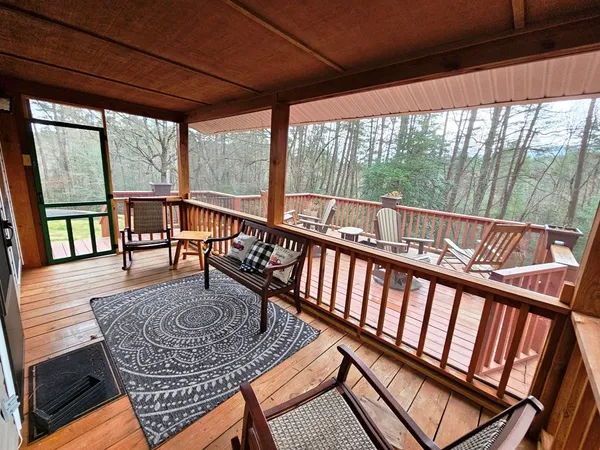 a view of a porch with furniture and wooden floor