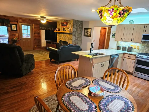 a living room with kitchen island furniture a chandelier and a wooden floor