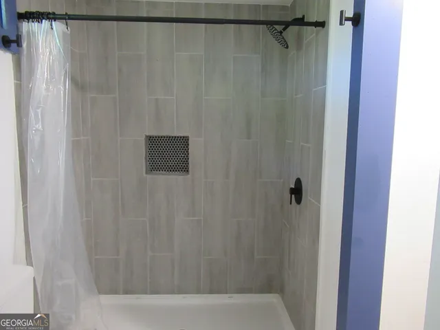 a bathroom with a shower and a curtain