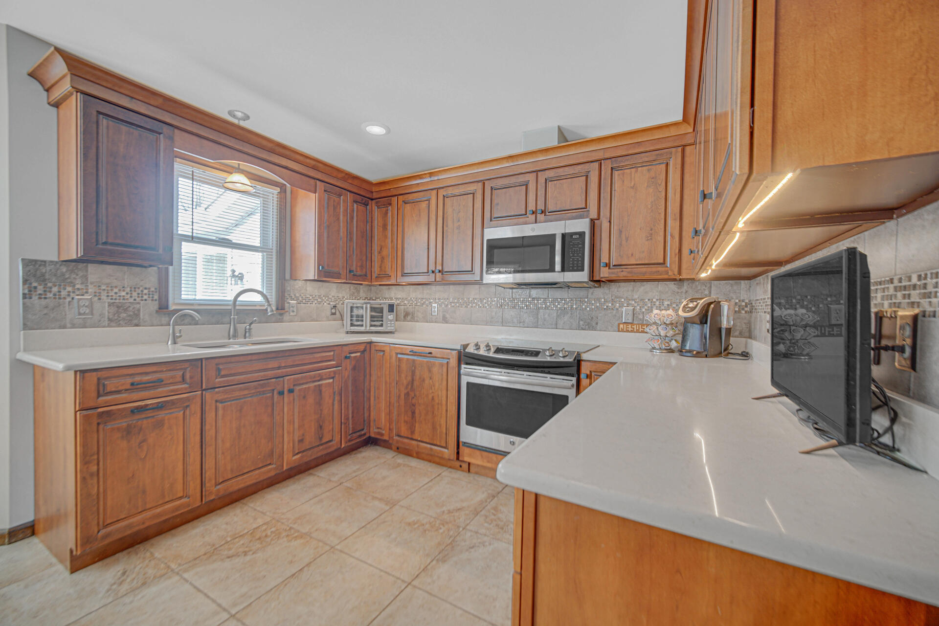 130 Wheatridge Road Valparaiso, IN 46385 - Photo 8 of 38 a kitchen with stainless steel appliances granite countertop a stove sink microwave and window