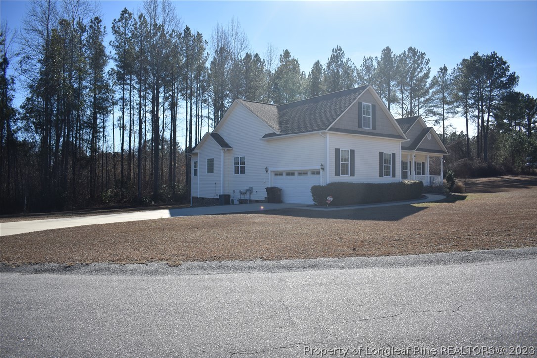 76 Ithica Lane Bunnlevel, NC 28323 - Photo 3 of 49 a front view of a house with a yard and trees