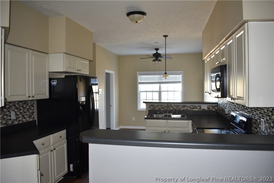 76 Ithica Lane Bunnlevel, NC 28323 - Photo 9 of 49 a kitchen with a sink a refrigerator and cabinets
