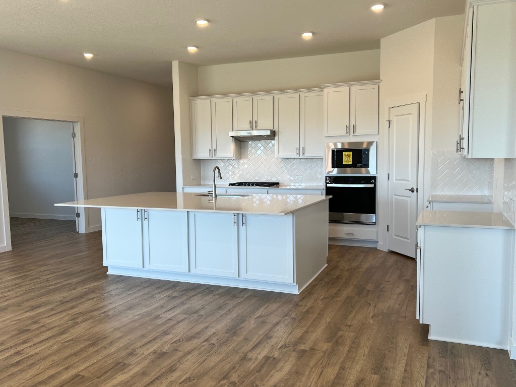 509 Prairie Wind Drive Leander, TX 78641 - Photo 5 of 9 a kitchen with stainless steel appliances granite countertop a stove a sink and white cabinets