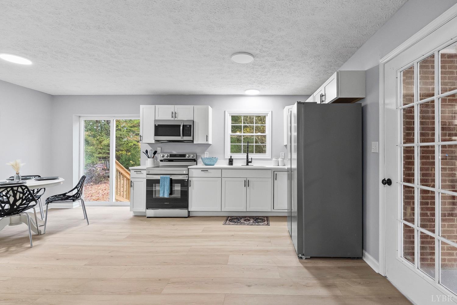 1077 Ringgold Road Ringgold, VA 24586 - Photo 28 of 35 a kitchen with granite countertop a refrigerator stove and microwave