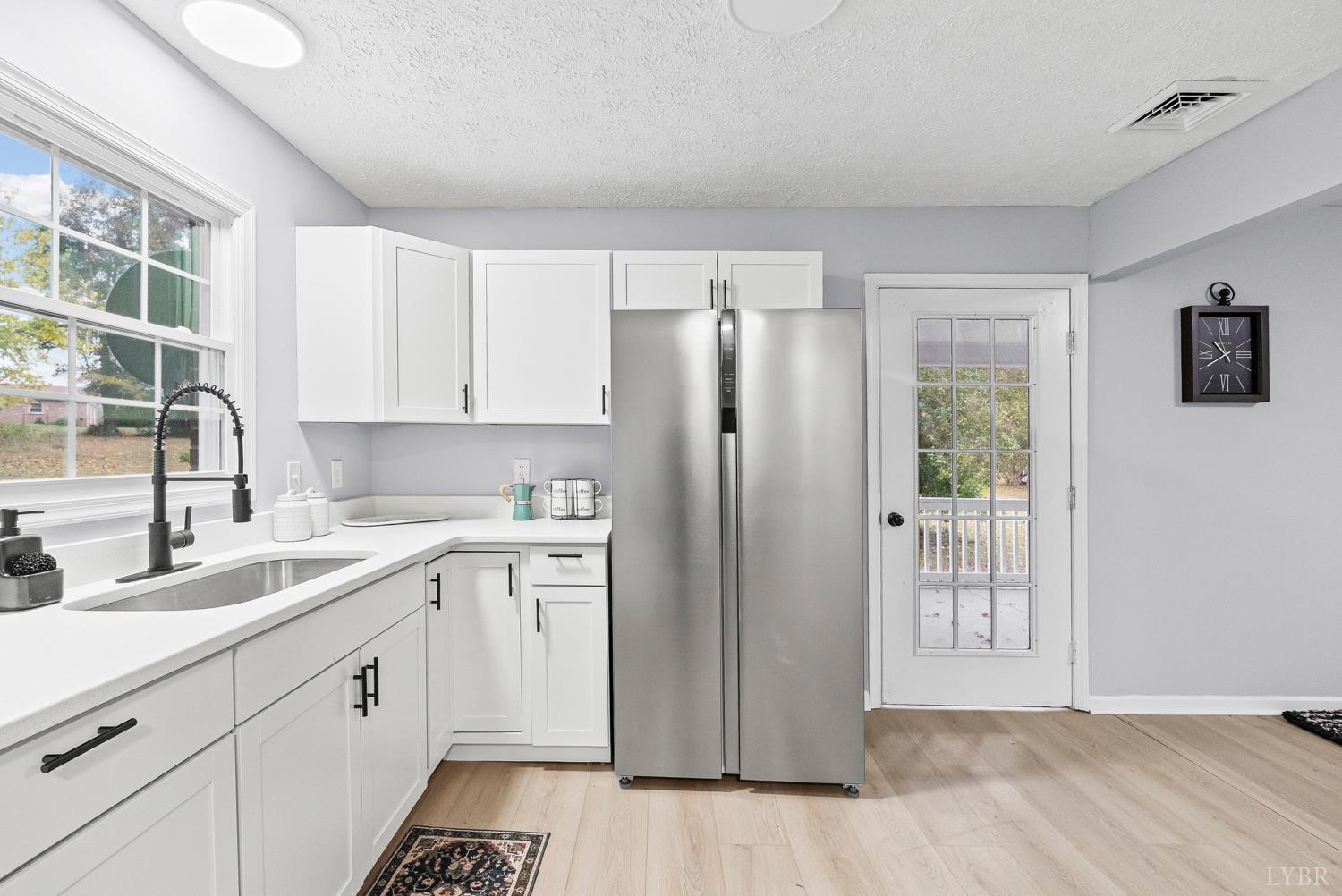 1077 Ringgold Road Ringgold, VA 24586 - Photo 29 of 35 a kitchen with a sink a refrigerator and cabinets