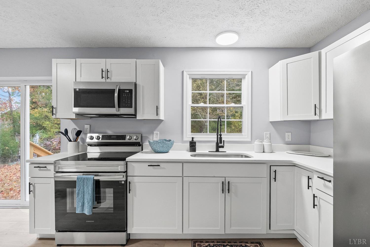 1077 Ringgold Road Ringgold, VA 24586 - Photo 30 of 35 a kitchen with stainless steel appliances a stove sink microwave and cabinets