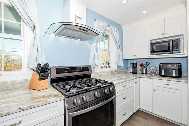 a kitchen with granite countertop stainless steel appliances and white cabinets