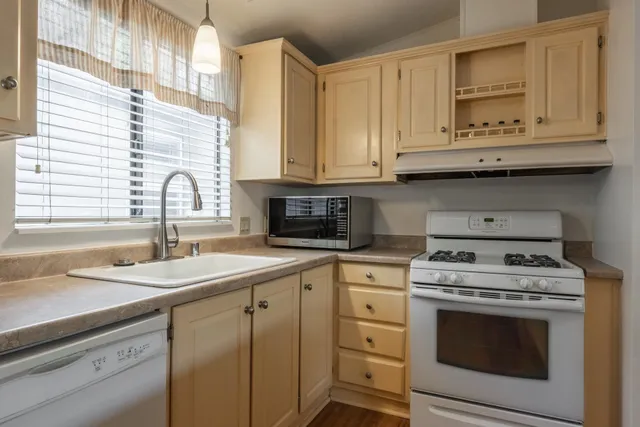a kitchen with granite countertop white cabinets and white appliances
