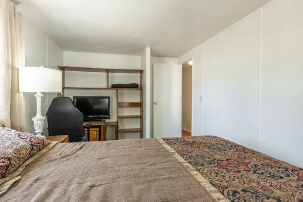 a bedroom with a bed a desk and chair