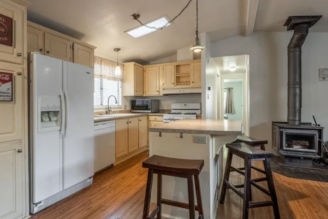 a kitchen with white cabinets and refrigerator