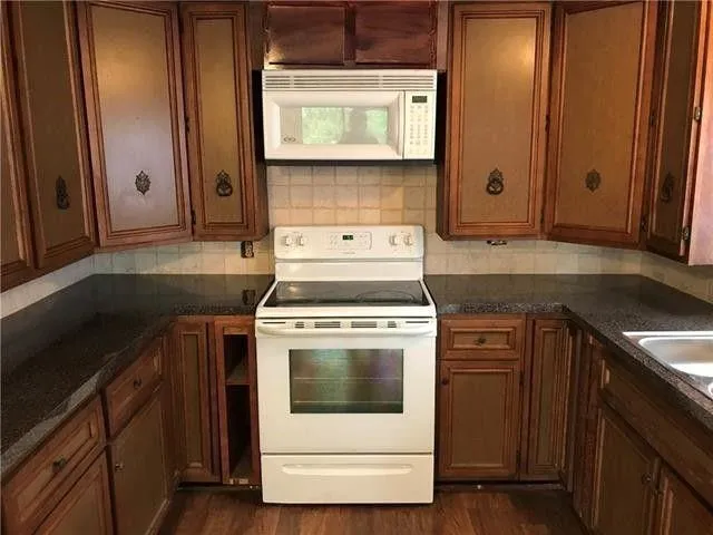 a kitchen with a stove sink and cabinets