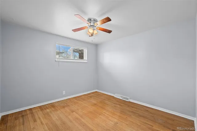 an empty room with a window and a ceiling fan