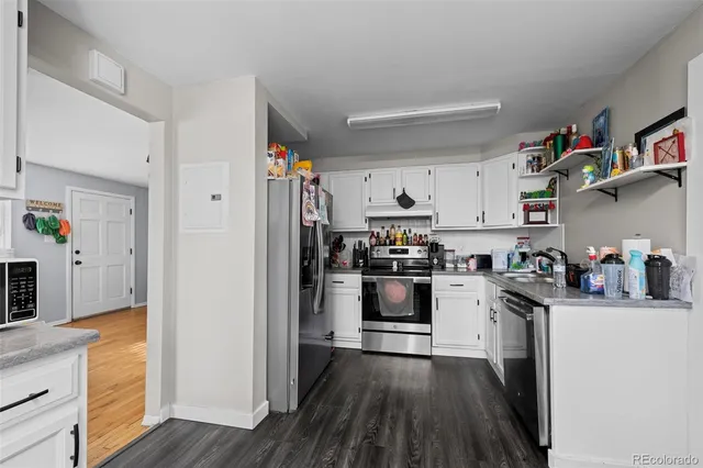 a kitchen with stainless steel appliances a sink cabinets and wooden floor