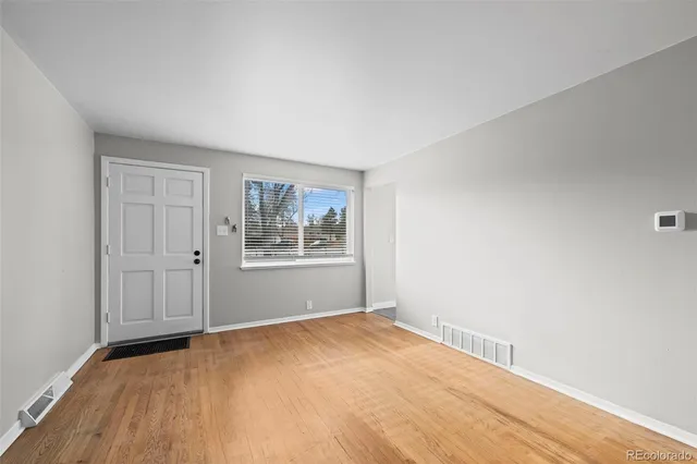 a view of empty room with wooden floor