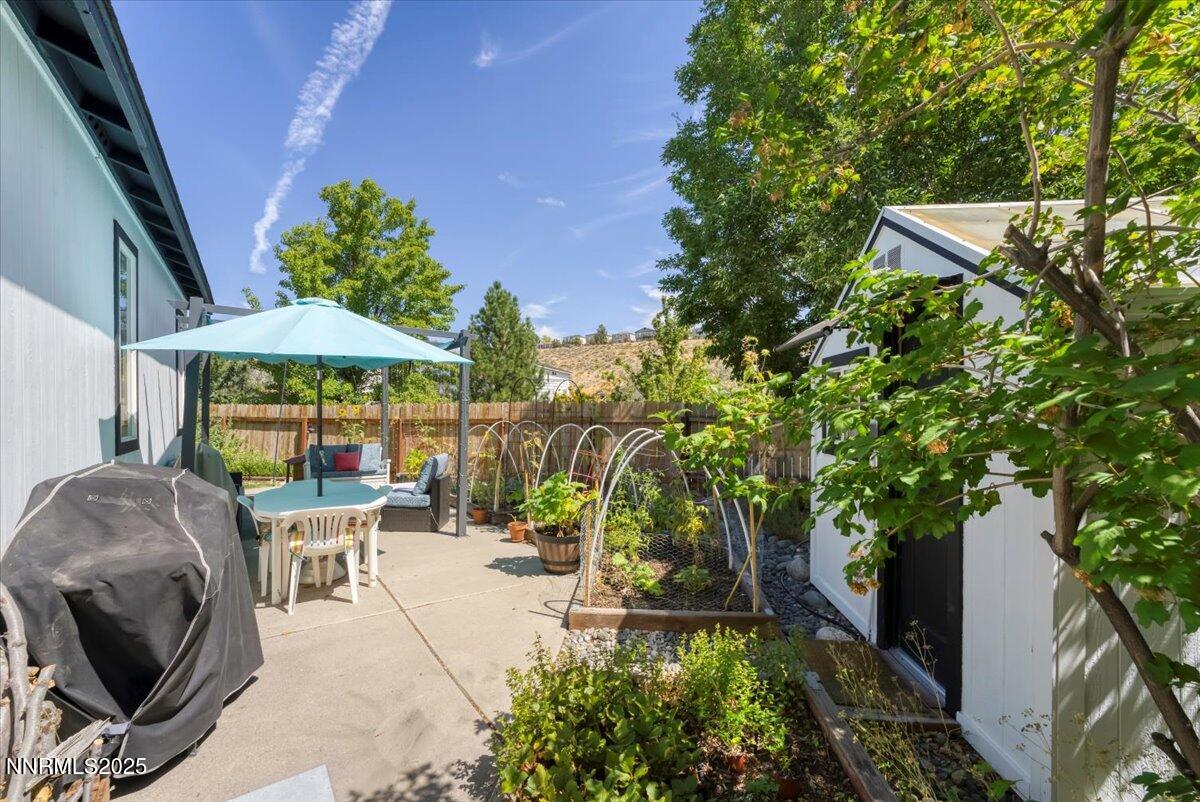 5921 Sapphire Ridge Court Reno, NV 89523 - Photo 23 of 31 a patio with glass top table and chairs under an umbrella