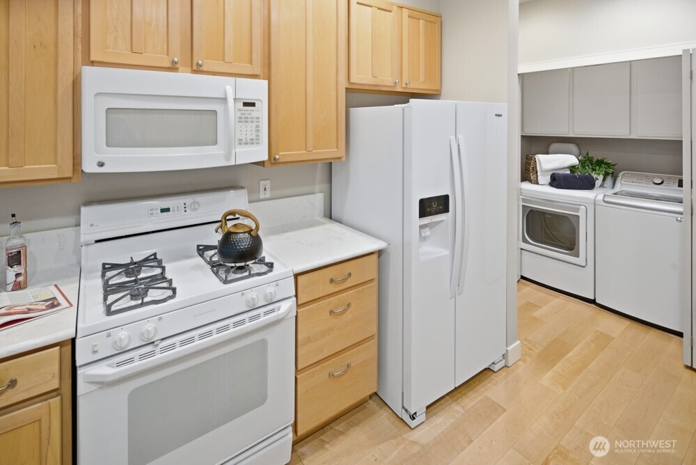 120 Newport Way Northwest, Unit 9 Issaquah, WA 98027 - Photo 19 of 40 a kitchen with refrigerator a stove a microwave and cabinets