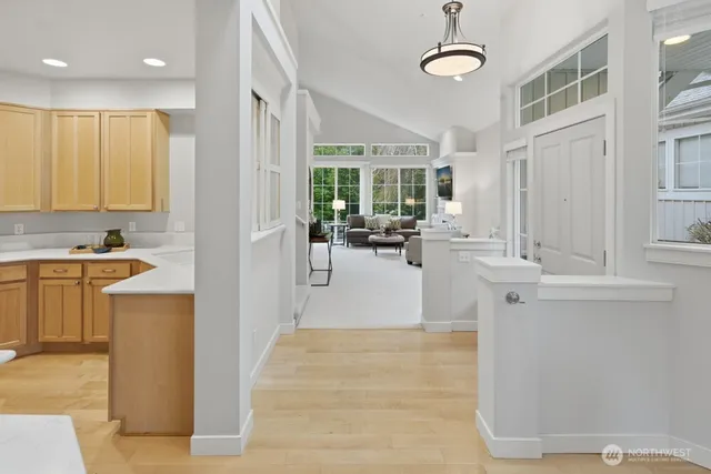 a view of a kitchen with kitchen island a large window cabinets a sink and stainless steel appliances