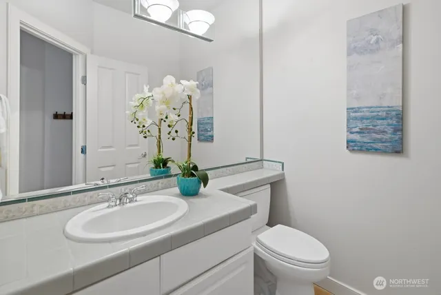 a bathroom with a sink toilet and a mirror