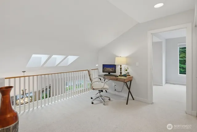 a view of a workspace with furniture and a window
