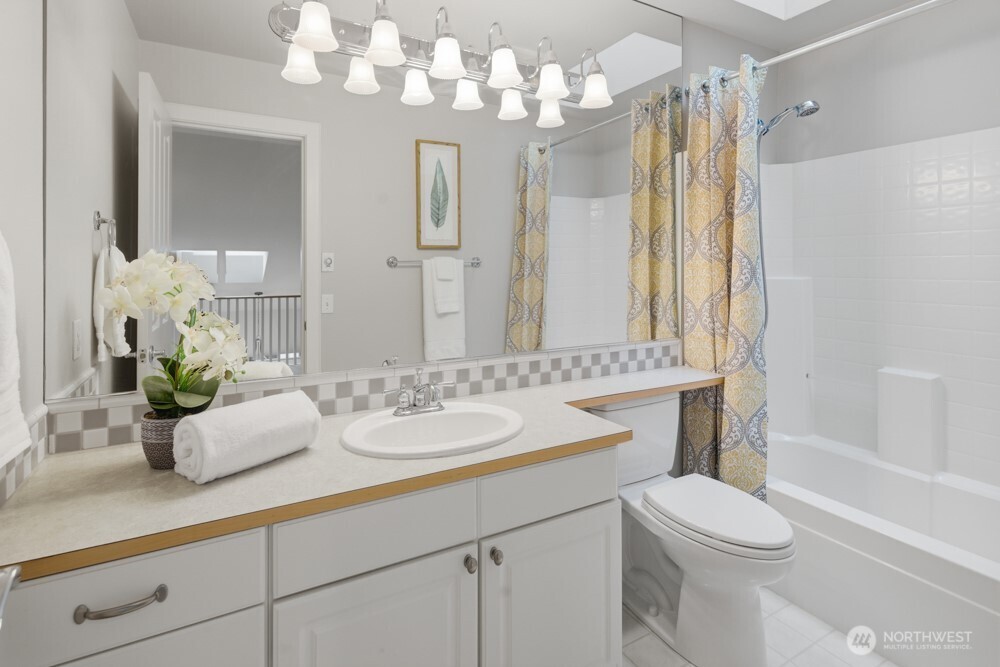 120 Newport Way Northwest, Unit 9 Issaquah, WA 98027 - Photo 30 of 40 a bathroom with a sink a toilet and a large mirror