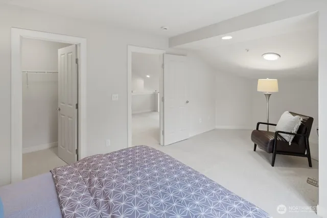 a spacious bedroom with a bed and a chair