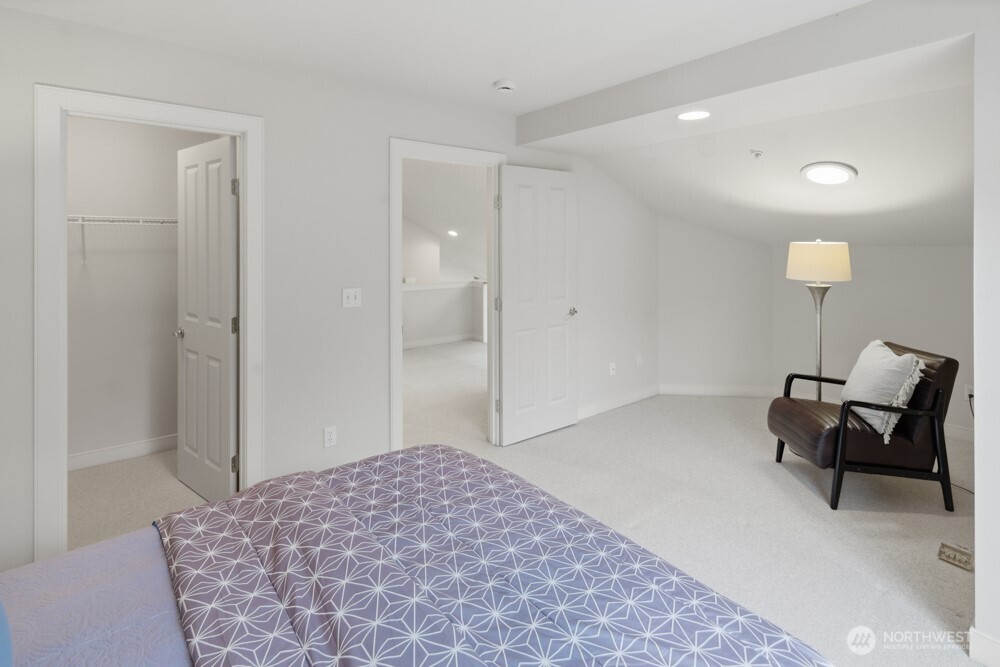 120 Newport Way Northwest, Unit 9 Issaquah, WA 98027 - Photo 32 of 40 a spacious bedroom with a bed and a chair