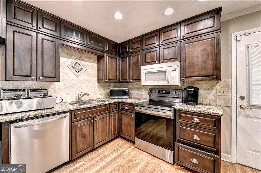 2486 Rex Road Ellenwood, GA 30294 - Photo 4 of 6 a kitchen with stainless steel appliances granite countertop a sink stove and refrigerator