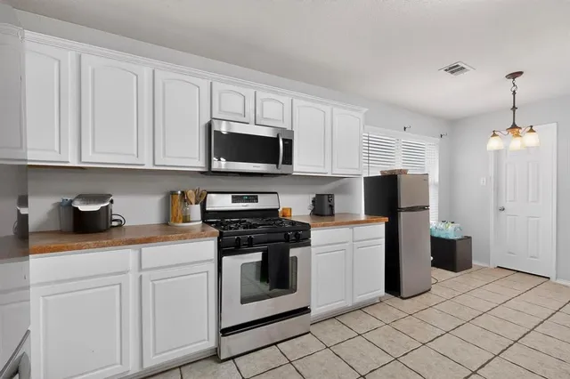 a kitchen with white cabinets and appliances