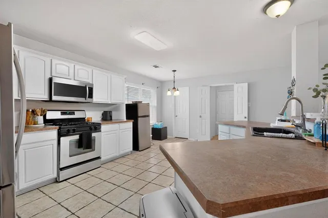 a kitchen with stainless steel appliances a stove a sink a microwave and cabinets