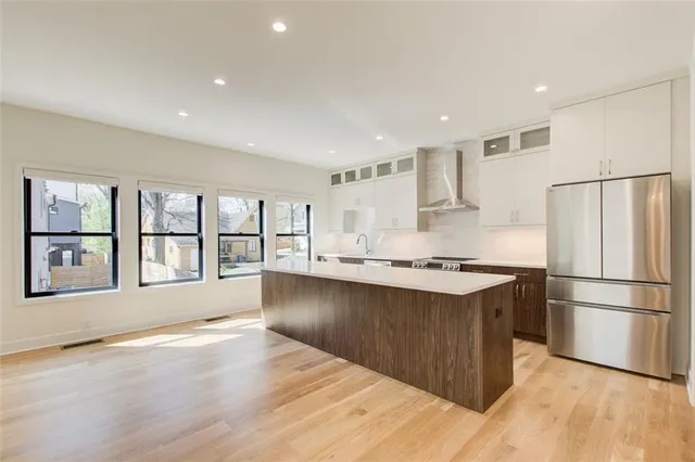 a kitchen with stainless steel appliances granite countertop a refrigerator a stove and a refrigerator