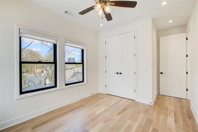 a view of an empty room with window and cabinet