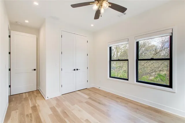 a view of an empty room with window and wooden floor