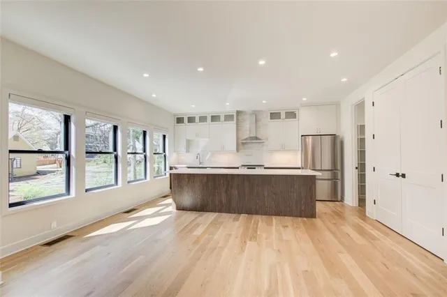 a large kitchen with stainless steel appliances granite countertop a large counter top and wooden floors