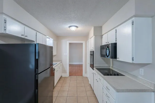 a large kitchen with a refrigerator and a sink