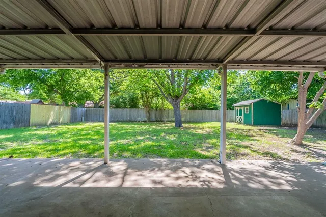 a view of a house with backyard and a tree