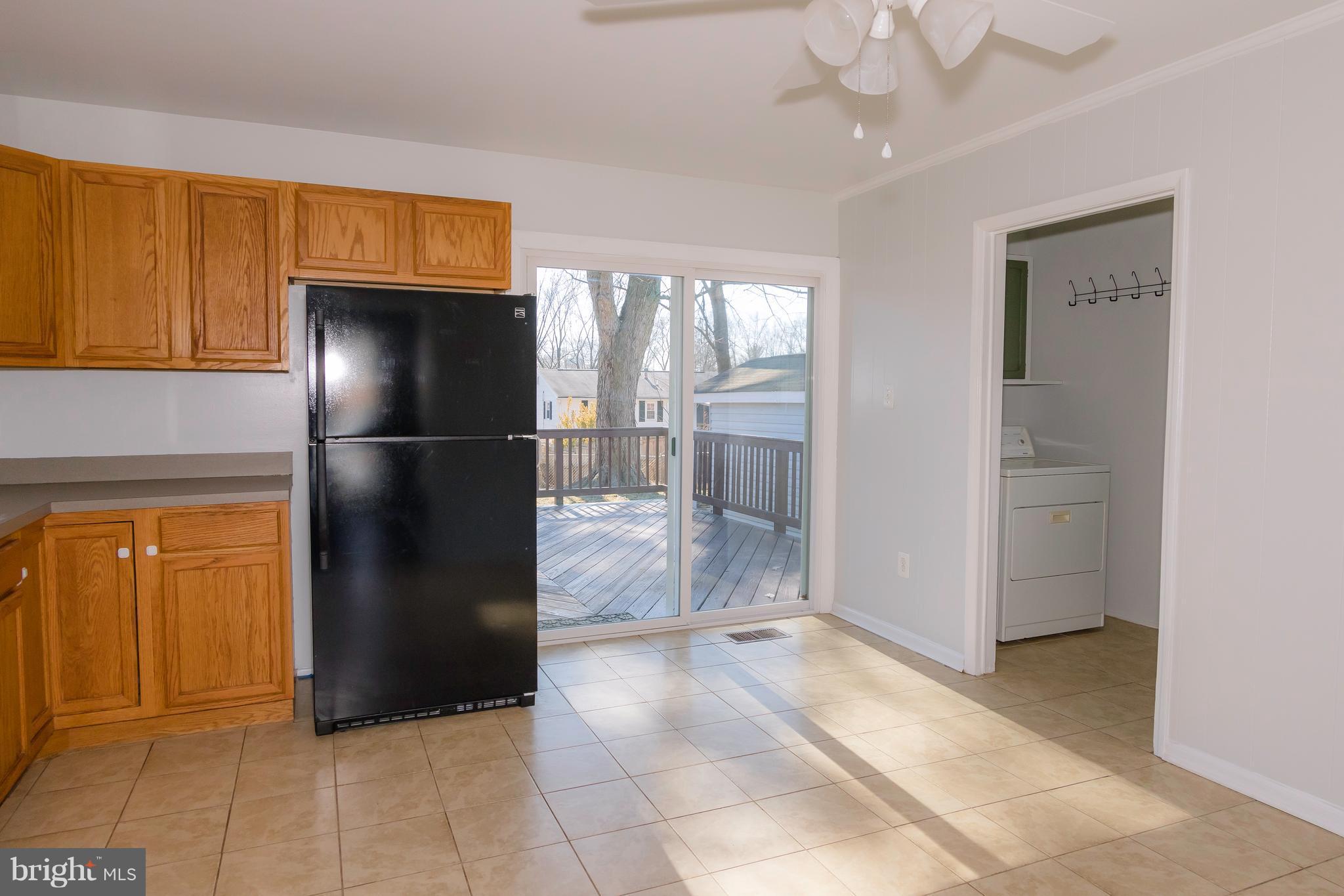 4141 Granby Road Woodbridge, VA 22193 - Photo 8 of 30 a view of a refrigerator in kitchen and an empty room in wooden floor