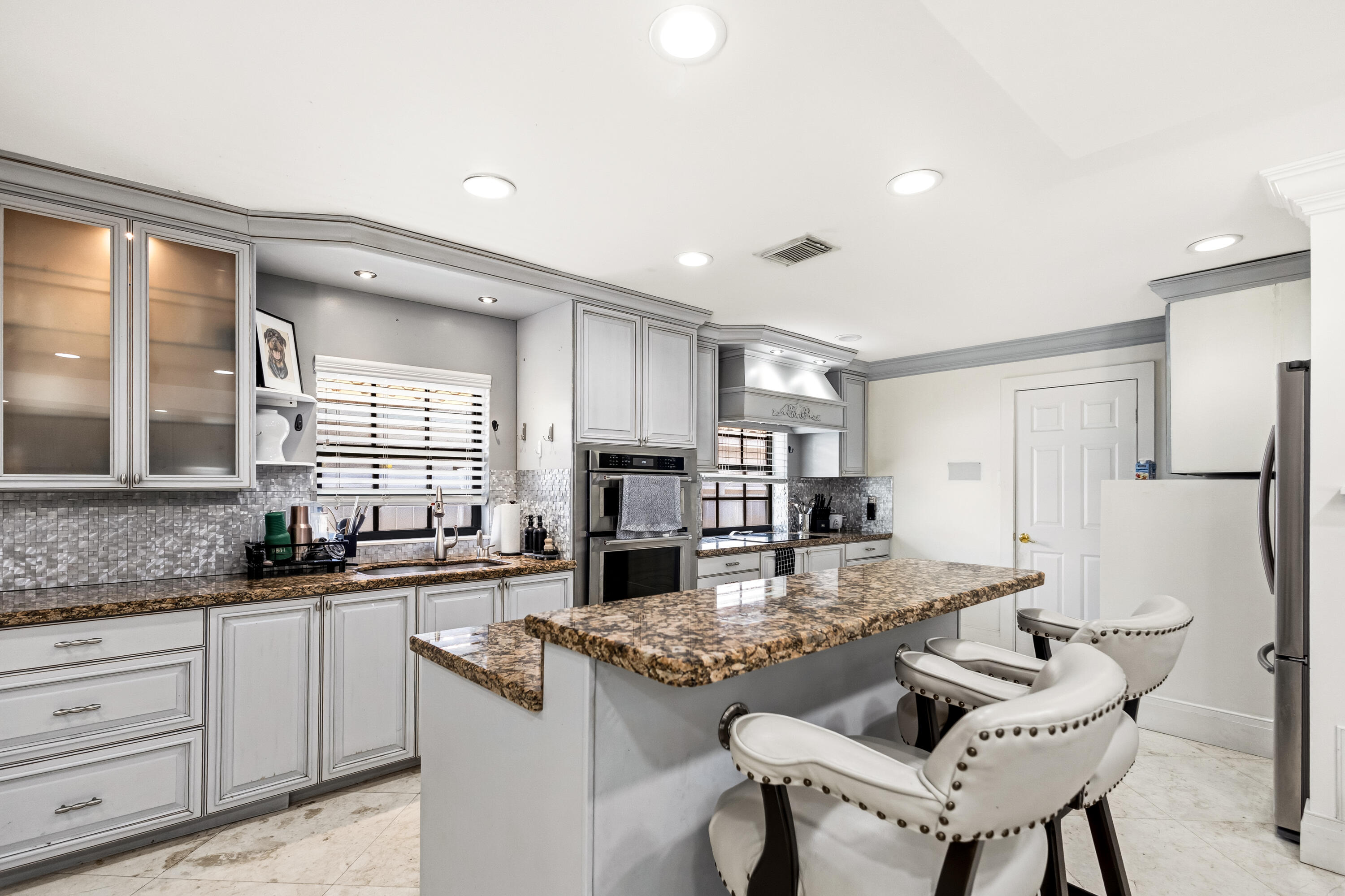 5223 Deerhurst Crescent Circle Boca Raton, FL 33486 - Photo 21 of 51 a kitchen with stainless steel appliances kitchen island granite countertop a sink and cabinets