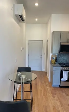 a kitchen with kitchen island stainless steel appliances a table and chairs in it