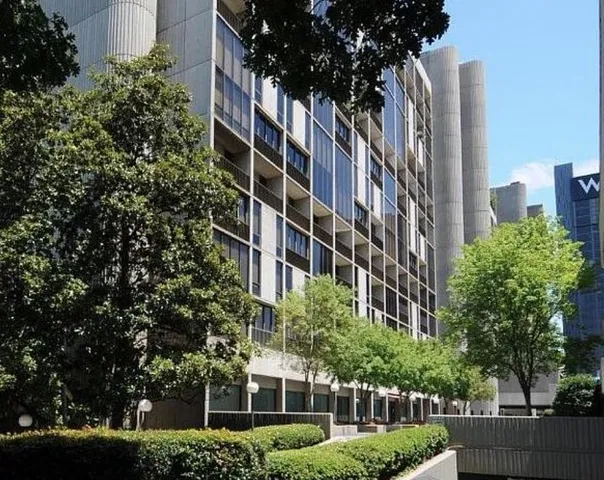 a living room with furniture a bookshelf and a window