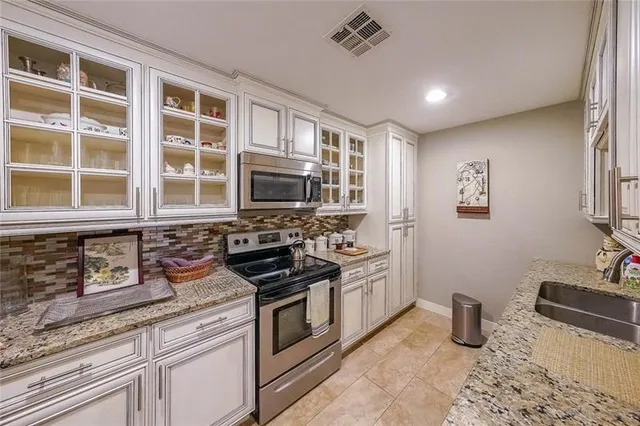 a kitchen with stainless steel appliances granite countertop a sink stove and refrigerator